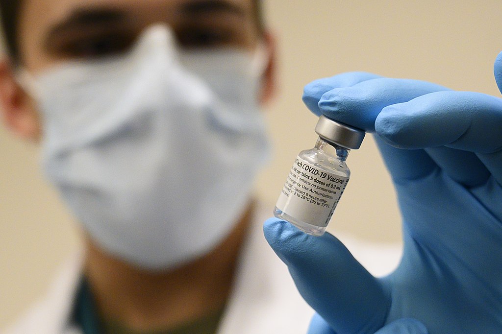 Scientist holding a vial of the Pfizer vaccine
