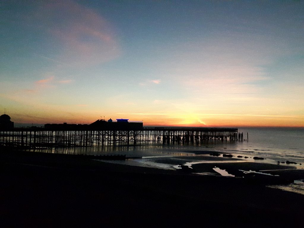 Hastings Pier with a sunrise in the background