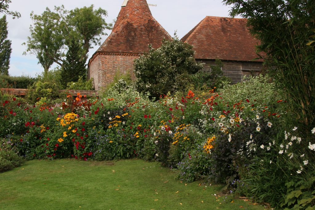 Oast house in background, exhuberant bedding in foreground